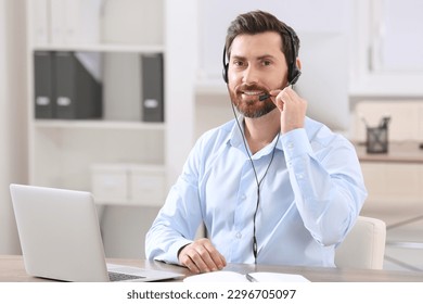 Hotline operator with headset working in office