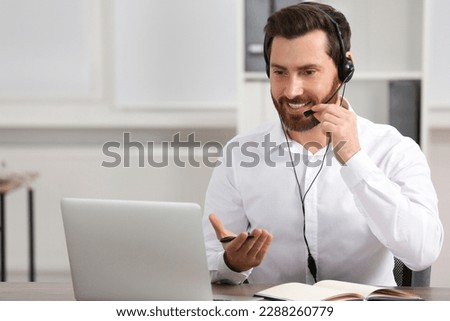 Hotline operator with headset working in office