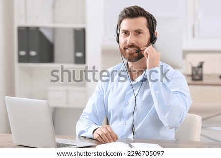 Hotline operator with headset working in office