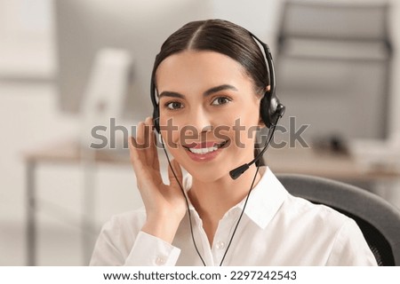 Hotline operator with headset working in office