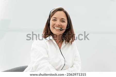 Hotline Operator. Portrait of smiling european lady customer service representative, wearing headset in call center indoors, looking at camera communicating with client. Support, contact us concept