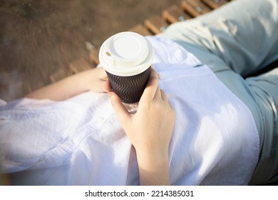 Hotography From Above Of Anonymous Woman, Holding Craft Paper Cup With Coffee Outside.