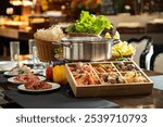 A hotpot setup with fresh ingredients and a pot amid a cozy dining atmosphere.