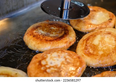 hotteok, Korean Syrup-filled Pancake : Fermented flour dough shaped into balls, filled with a spoonful of brown sugar, and pan-fried in a preheated pan. Brown sugar mixed with cinnamon powder is a com - Shutterstock ID 2236581297