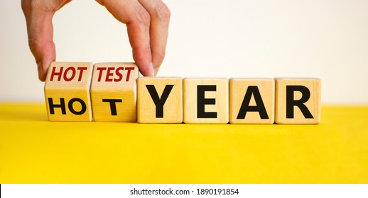Hottest year and global warming concept. Hand turns cubes and changes words 'hot year' to 'hottest year'. Beautiful yellow table, white background. Business and hottest year concept. Copy space. - Shutterstock ID 1890191854