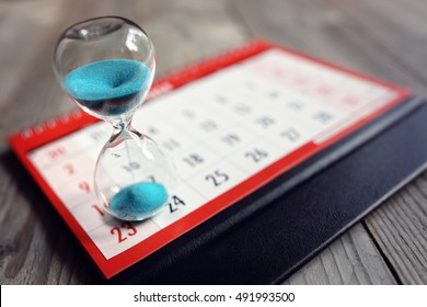 Hour glass on calendar concept for time slipping away for important appointment date, schedule and deadline