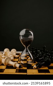 Hourglass And Chessboard On A Dark Background. Strategy, Management Or Leadership Concept. Vertical Image