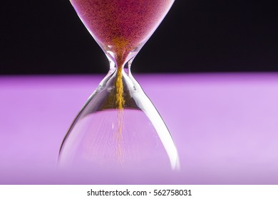 Hourglass Egg Timer Isolated On Purple And Black Background With Copy Space.