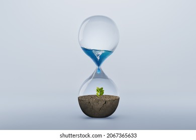 Hourglass with fresh water drop to green plant planting on dry land isolated background, metaphoric of saving water, Drought and Climate change.