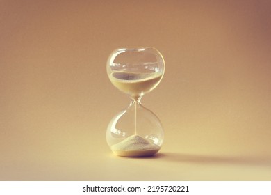 Hourglass, Also Known As Sandglass, Sand Timer, Sand Clock. Single Yellow Object On Earth Colored Beige Orange Paper. Monochromatic Background Image.