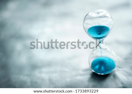 Hourglass on blue background with copy space concept for time