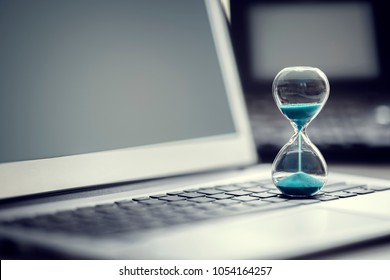 Hourglass on laptop computer concept for time management and countdown to deadline - Shutterstock ID 1054164257