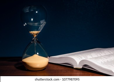 Hourglass And An Open Bible Symbolizing The End Times According To The Holy Bible.