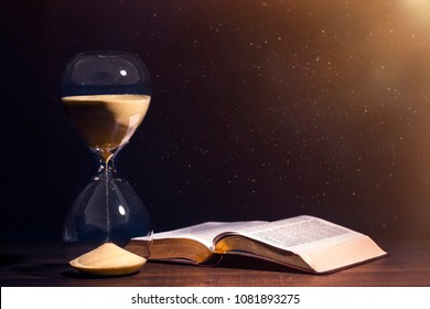 Hourglass And Open Bible Symbolizing The End Times According To The Holy Bible. Time Is Running Out.