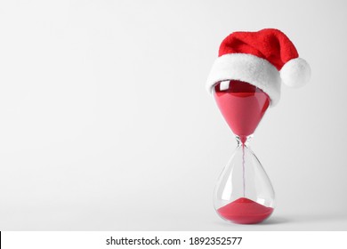 Hourglass With Santa Hat Isolated On White. Christmas Countdown