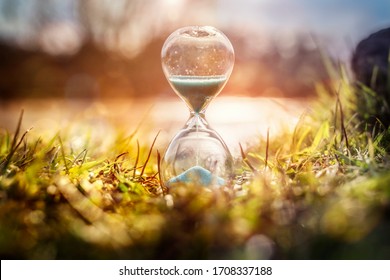 Hourglass at sunset by water concept for time passing