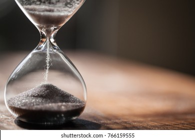 Hourglass As Time Passing Concept For Business Deadline, Urgency And Running Out Of Time. Sandglass, Egg Timer On Wooden Floor Showing The Last Second Or Last Minute Or Time Out.  With Copy Space.