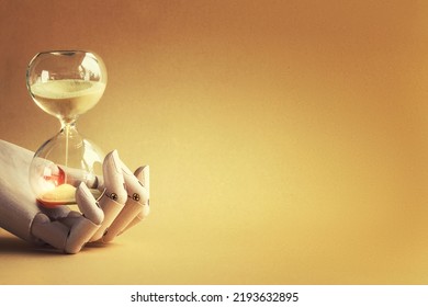 Hourglass In Wooden Hand Model. Hourglass Is Also Known As Sandglass, Sand Timer, Sand Clock. Yellow Objects On Vibrant Orange Paper. Monochromatic Background Banner With Copy-space, Place For Text.