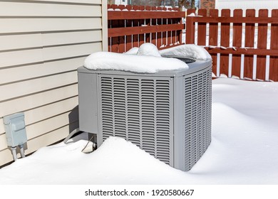 House Air Conditioning Unit Covered In Snow During Winter.. Concept Of Home Air Conditioning, Hvac, Repair, Service, Winterize And Maintenance.
