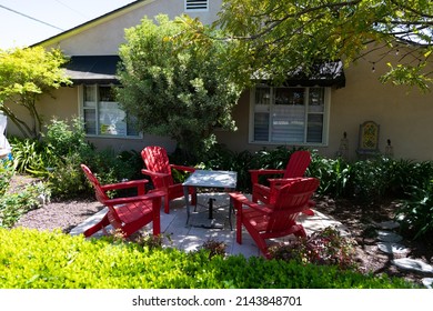 House Backyard With Red Adirondack Chairs And Table Outdoors Setting Furniture In Summer