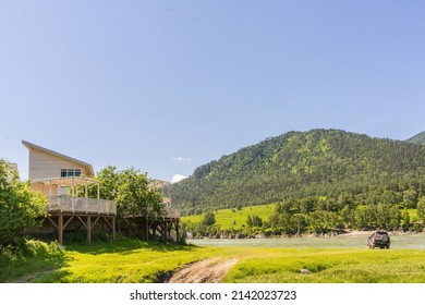 House with a balcony on the banks of the Katun River in summer