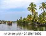 House boat in backwaters near palms in Alappuzha, Kerala, South India