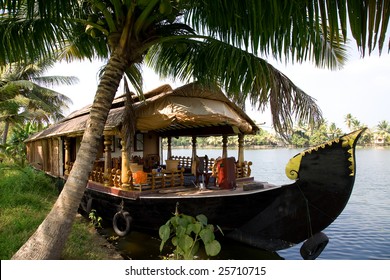 House boat in India over tropical palm on the river
