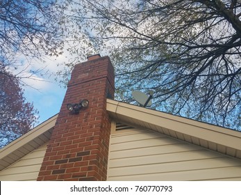 House With Brick Chimney And Flood Light And Satellite Dish