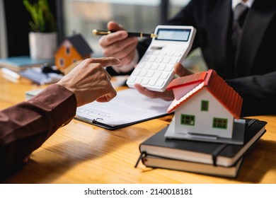 House Broker Who Calculates Prices To Offer Special Promotions. Selling A House With Insurance, Salesperson Or And Free Insurance For Customers Who Buy A Model Home