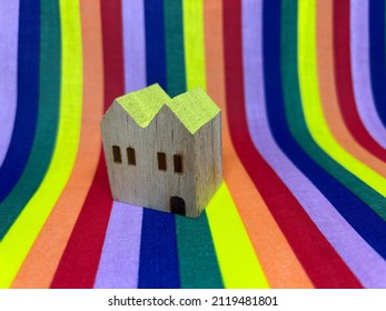 A house built in front of a rainbow backdrop; the concept of an LGBT, Homosexual family.