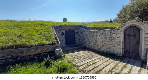 House or bunker built of stone underground with solid wood door and natural grass roof