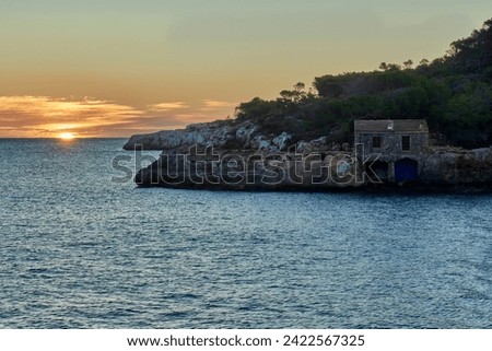 the house by the Mediterranean sea in a deserted cove at dawn