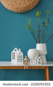 House candle holders, wooden mannequin and houseplant on table near blue wall - Shutterstock ID 2258392503