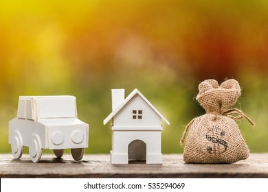 A House And Car Model And Money Bag For Loans Concept.