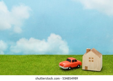 House And Car On Green Grass Over Blue Sky And Clouds. My Home And Car Concept.