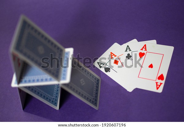 House of cards with some poker cards beside\
over a purple\
background\
