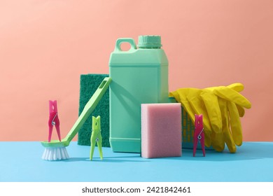 House cleaning plastic product on pink background and blue plain with plastic canister, sponges, brush, rubber gloves and clothespins. Home service or housekeeping concept. - Powered by Shutterstock