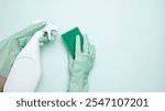 House cleaning. Womans hand in rubber glove holds green dishwashing sponge and cleaning product