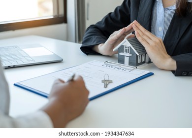 The house is covered by the hands of a real estate agent to protect the house for customers, homebuyers, insurance, ready give to with new owner. Home insurance sales concept.