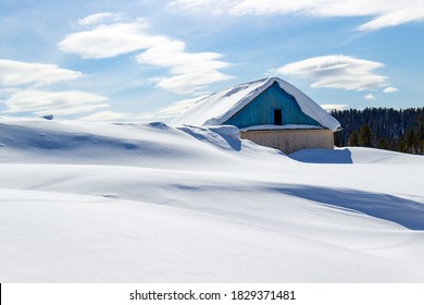 House covered in snow. Winter landscape with wooden building in deep snowdrift in sunny day in Siberia. Winter Christmas tale concept