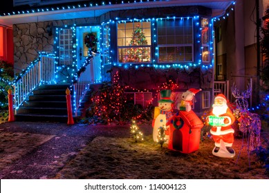 House Decorated With Christmas Lights And Ornaments In Front Lawn