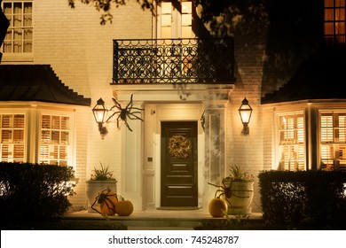 The House Is Decorated For Halloween: Pumpkins With Spiders, A Wreath On The Door. Night