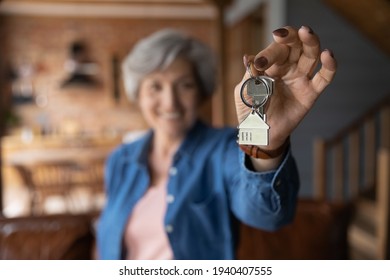 House Of Dream. Blurred Portrait Of Happy Elderly Female Of Senior Age Becoming Landlord Homeowner Pose In Modern Country Cottage Hold Bunch Of Keys Celebrate Moving Day. Focus On Key In Old Lady Hand