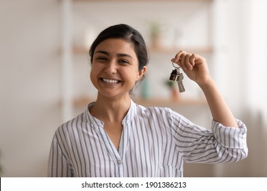 House of dream. Headshot portrait of excited indian female happy winner buyer renter tenant of new home apartment. Young mixed race woman proud homeowner looking at camera showing keys of modern flat - Shutterstock ID 1901386213