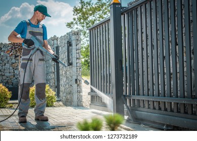 House Driveway And The Gate Pressure Washing By Caucasian Men