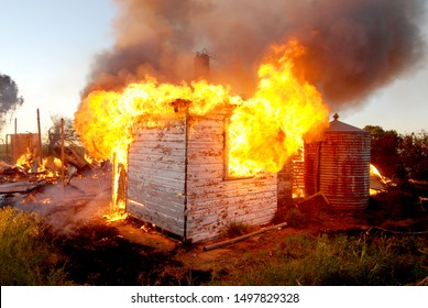 House Engulfed In Fire With Most Of The House Burnt To The Ground, And A Corrugated Iron Tank In Rural New South Wales Australia