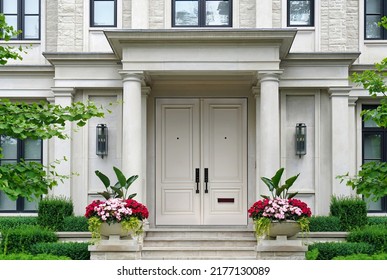 House Entrance With Columns Surrounded By Pots Of Flowers