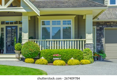 House Entrance With Porch And Nicely Trimmed And Landscaped Front Yard.