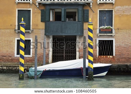 House entrance in Venice with striped poles in blue and yellow