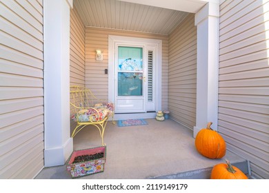 House exterior with beige vinyl lap siding and glass storm door over the wreath on the front door